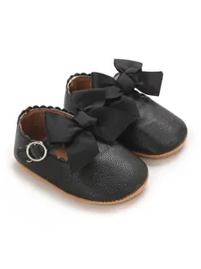 Detailed view of black PU leather baby girl princess shoes with large ribbon bows