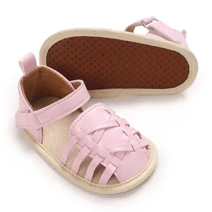 Vue détaillée de chaussures de marche tressées roses pour bébé avec semelle en caoutchouc souple