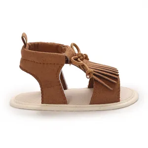 Macro side view showing the fringe detail and soft sole of these brown baby walking sandals