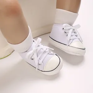 Macro view of white infant canvas sneakers with soft soles for babies aged 0-1.