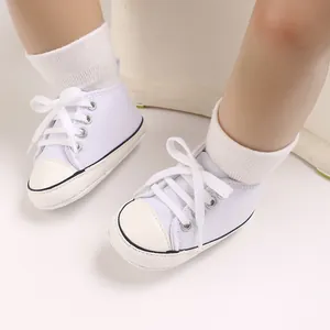 Close-up detail view of white infant canvas sneakers with soft rib socks for babies