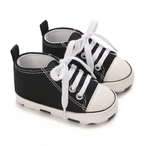 Detailed view of black and white baby canvas sneakers with soft soles for infants
