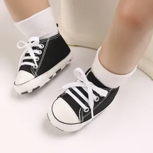 Detail view of black and white infant canvas sneakers worn with cozy white socks