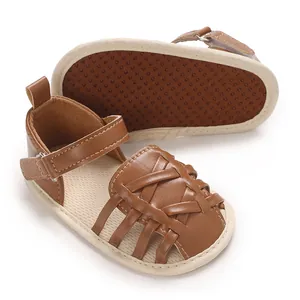 Vue détaillée de sandales en cuir marron tressé pour bébé avec semelles souples