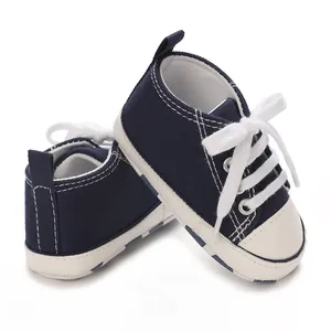 Detailed view of navy blue baby canvas sneakers with soft soles and white laces