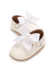 Close-up view of white PU leather baby girl princess shoes with large ribbon bows