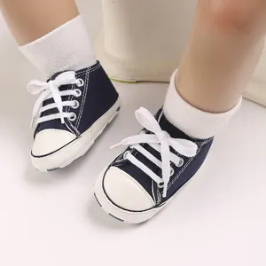 Detailed close-up of navy blue baby canvas sneakers with white laces for 0-1 year olds.