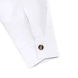 Detailed close-up view of a white linen shirt cuff featuring a dark marble button