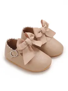 Detail view of beige PU leather baby princess shoes with large ribbon bows