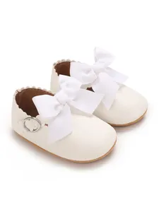 Detailed view of white PU baby princess shoes featuring large elegant ribbon bows