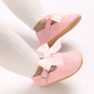 Macro view showing the soft PU leather and ribbon bow detail of pink baby princess shoes