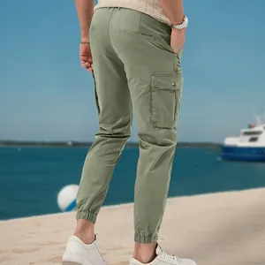 Detail view of men's olive green cargo jogger pants with side pockets and elastic cuffs.