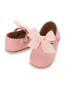 Close-up of pink PU leather baby princess shoes with large ribbon bows