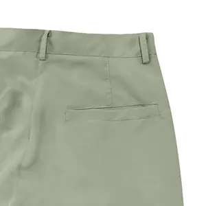 Detail view of the back welt pocket and belt loops on casual men's light green cargo pants.