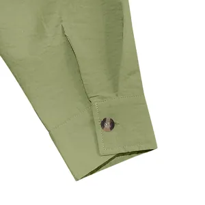 Detailed macro shot of a sage green linen shirt cuff showing fine fabric texture