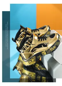 Detailed view of boys metallic gold high-top sneakers with graffiti print soles