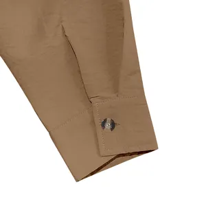 Close-up of a buttoned cuff on a men's vintage-style khaki linen-textured shirt