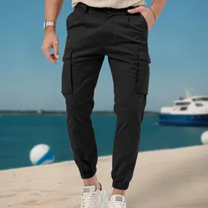 Detail shot of black multi-pocket cargo jogger pants for men in an outdoor beach setting