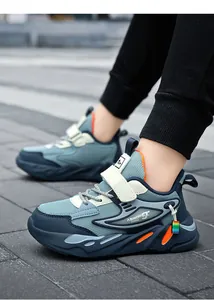 Vue détaillée de baskets de course en mesh bleu pour garçons avec bande velcro sur pavé.