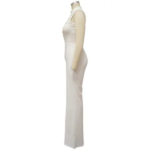 Side view of a sexy sleeveless white wide leg jumpsuit featuring a high neck and gold chain detail