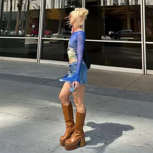 Side view of a woman wearing a blue printed off-shoulder long sleeve top outdoors