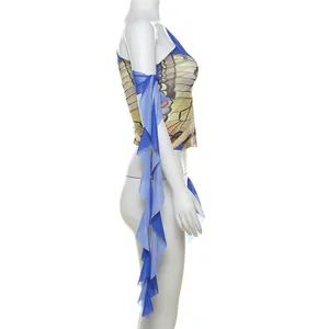 Detail of blue one-shoulder top featuring vibrant butterfly print and flowing ruffles