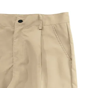 Detailed close-up of khaki cargo pants waist showing button and pocket stitch texture.