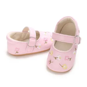 Detailansicht von rosa Baby-Prinzessin-Schuhen mit Blumenstickerei und Riemchen.