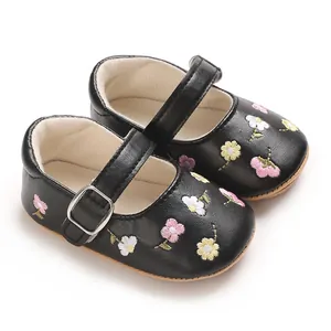 Nahaufnahme schwarzer Babyschuhe für Mädchen mit zarten Blumenstickerei-Details