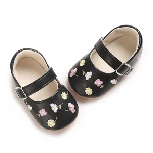 Nahaufnahme von schwarzen Baby-Mary-Jane-Schuhen mit feinen Blumenstickereien