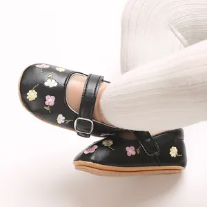 Detailansicht von schwarzen Babyschuhen für Mädchen mit Blumenstickerei und Gummisohle
