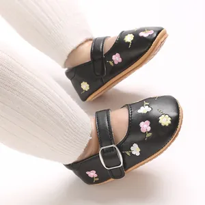 Nahaufnahme schwarzer Baby-Prinzessinenschuhe mit Blumenstickerei und Schnalle