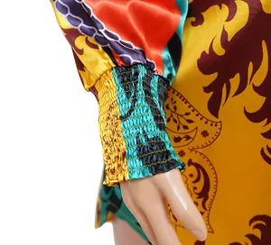 Detailed close-up of the elastic smocked cuff on a colorful Baroque print satin shirt