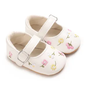 Detailansicht weißer Babyschuhe für Mädchen mit feiner Blumenstickerei und Riemchen