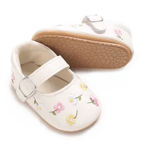 Detailansicht der bestickten weißen Babyschuhe mit rutschfester Gummisohle für Mädchen.