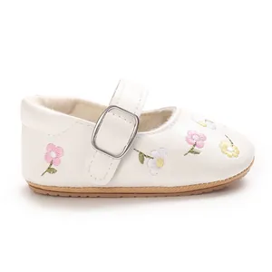 Detailansicht weißer Baby-Prinzessinenschuhe mit feiner Blumenstickerei und Gummisohle