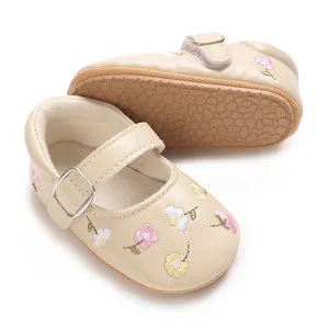 Detailansicht von beigen Baby Mary Janes mit Blumenstickerei und rutschfester Gummisohle