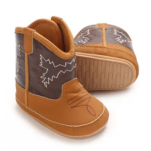 Vue détaillée de la semelle antidérapante et broderie des bottes cowboy bébé marron.