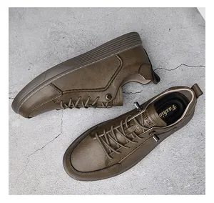Top view of brown leather casual work shoes with elastic laces on a grey background.