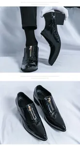 Close-up of stylish glossy black men's pointed-toe dress shoes with gold zipper detail