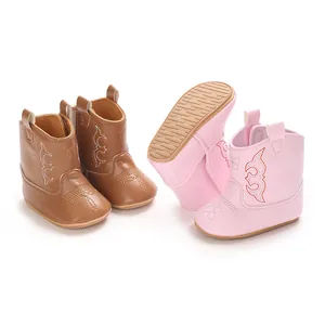 Detailed view of pink and brown infant cowboy boots with anti-slip rubber soles