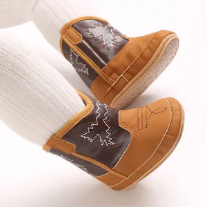 Vue détaillée de bottes de cowboy marron pour bébé avec coutures en zigzag et collants