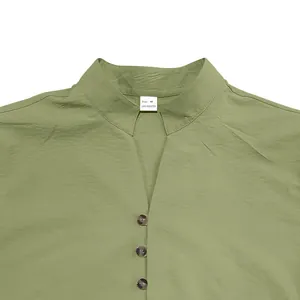 Close-up detail of sage green retro men's shirt with stand collar and buttons.