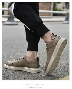 Detailed view of men's retro khaki leather casual shoes worn outdoors on asphalt.