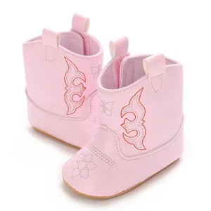 Macro view of pink soft PU leather baby boots with embroidered flower details.
