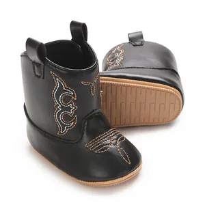 Detailed view of black PU baby cowboy boots featuring embroidery and non-slip textured soles