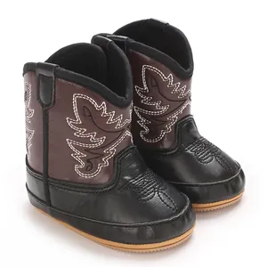 Détail de bottes de cowboy élégantes marron et noir pour bébé fille pour l'hiver