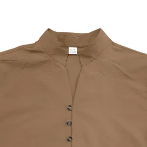 Close-up detail of a brown men's shirt showing the stand collar and button neckline.