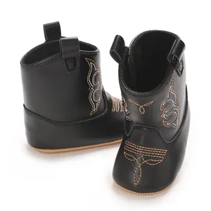 Macro detail view of black PU leather baby cowboy boots showing embroidered patterns