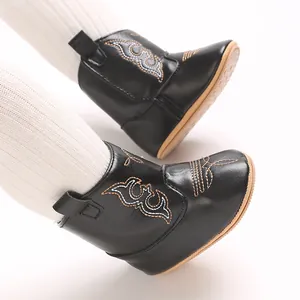 Detailed close-up of black baby boots featuring white embroidery and non-slip rubber soles